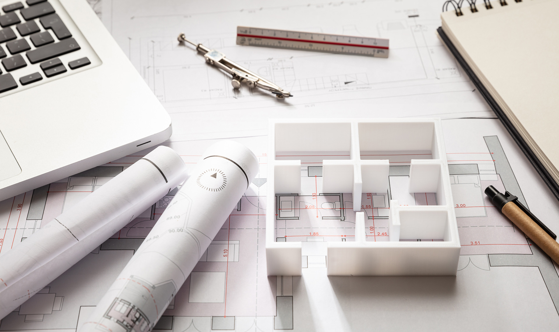 Rawf8 © Adobe Stock Gebäudezeichnungen auf einem Schreibtisch mit Laptop und Zeichenutensilien - by Rawf8 © Adobe Stock